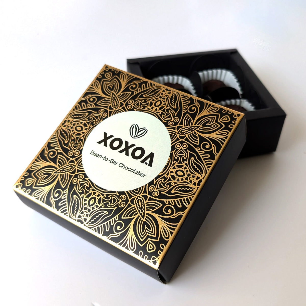 Xoxoa bonbon box with black and gold foil pattern and round logo seal